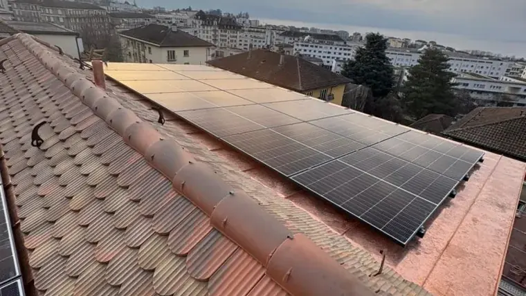 Panneaux solaires noirs sur un toit de tuiles, Suisse romande